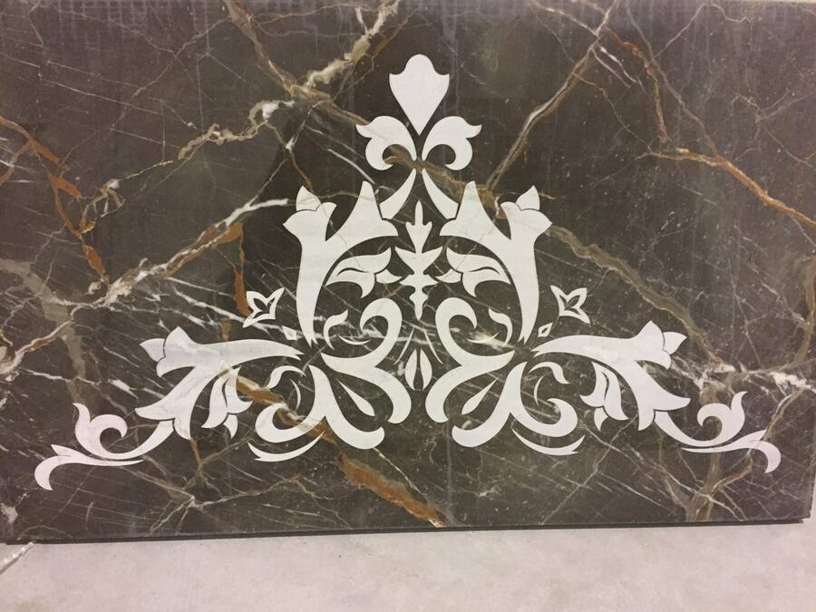 Decoro damascato bianco inciso su marmo nero venato oro