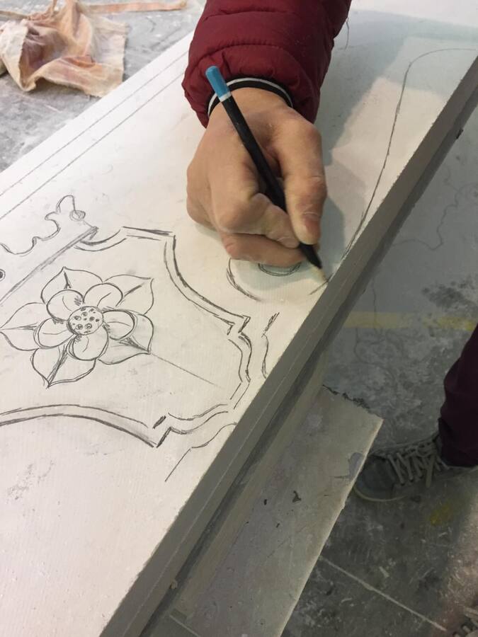 Tracciatura a mano di un decoro floreale direttamente sulla lastra di pietra