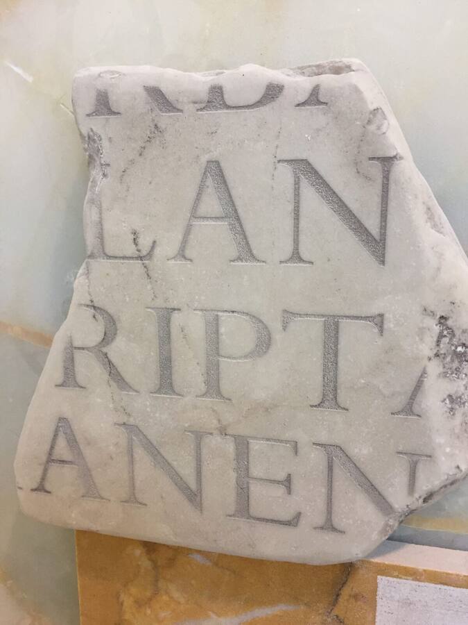 Iscrizione in capitale romana incisa su lastra di marmo bianco