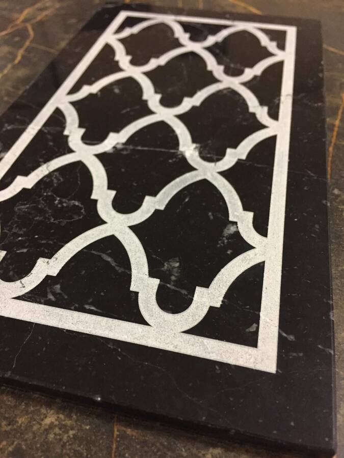 Pannello traforato con motivo geometrico, marmo bianco su fondo nero